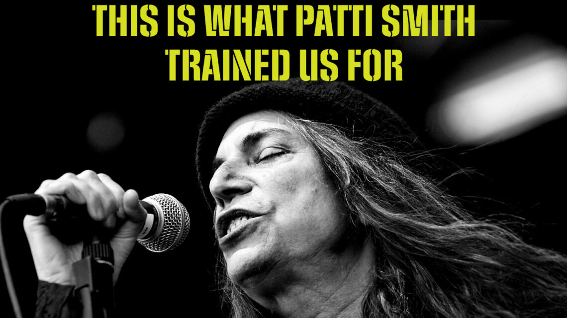 In the bottom half of the image is a black and white photo of Patti Smith from the neck up, singing into a microphone. Above her is text in acid green all caps in a stencil typeface: "This is not a time to be dismayed / This is Rock 'n Roll time / This is what Patti Smith trained us for." In small acid green condensed type across the center bottom: "Design: IG @nicola_ginzler - www.nicolaginzler.com - Inspo: Henry Rollins & Rasmenia Photo: Beni Köhler, CC BY-SA 3.0, https://commons.wikimedia.org/w/index.php?curid=3390571"